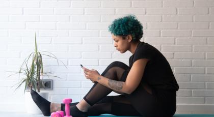 woman looking at exercise apps on phone