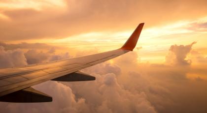 Aircraft wing on the clouds of sunset