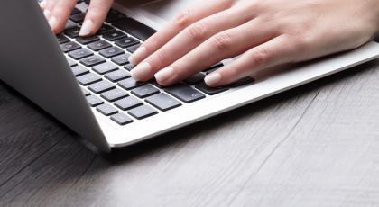 A woman's hands on a laptop