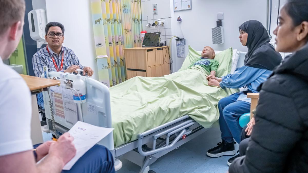  A physio student talking to the interpreter, a high-tech child manikin simulating the patient and ‘patient relatives’